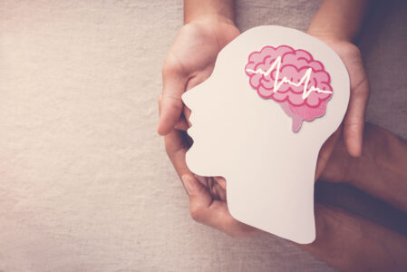 Adult and child hands holding encephalography brain paper cutout Adult and child hands holding encephalography brain paper cutout, Epilepsy and alzheimer awareness, seizure disorder, mental health concept